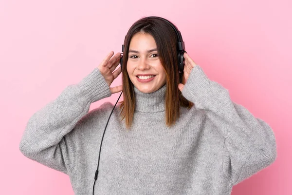 Νεαρή Γυναίκα Ακούει Μουσική Ακουστικά Πάνω Από Απομονωμένο Ροζ Τοίχο — Φωτογραφία Αρχείου