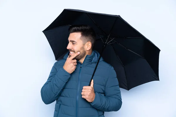 孤立した背景の上に傘を持っている男は考えと側を見て — ストック写真
