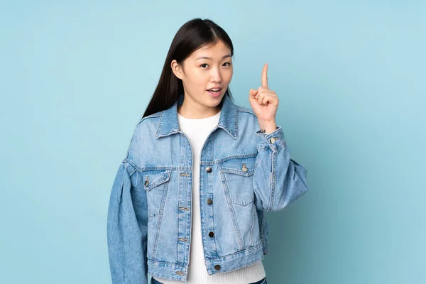 指を指差すアイデアを背景に孤立した若いアジア人女性 — ストック写真