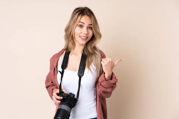 Jonge Fotografe Meisje Geïsoleerde Achtergrond Wijst Naar Zijkant Een Product — Stockfoto