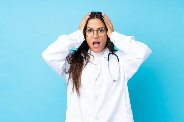 Junge Ärztin Über Isoliertem Blauem Hintergrund Mit Überraschendem Gesichtsausdruck — Stockfoto