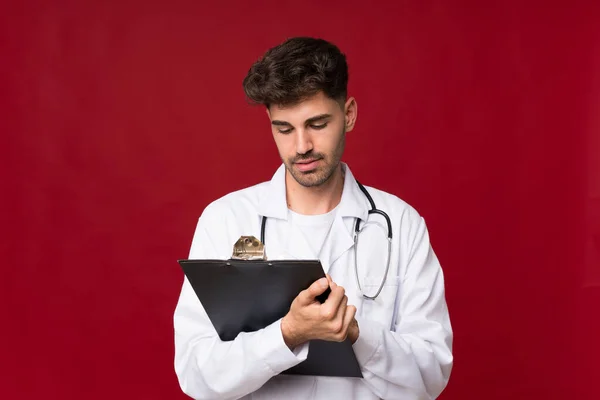 Young Man Isolated Background Doctor Gown Writing Folder — Stock Photo, Image