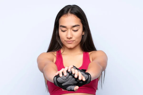 Joven Mujer Deportiva India Aislada Sobre Fondo Azul Brazo Estiramiento —  Fotos de Stock