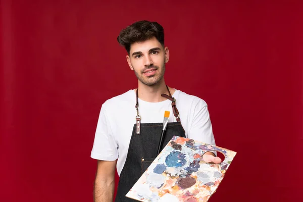 Jovem Sobre Fundo Isolado Segurando Uma Paleta — Fotografia de Stock