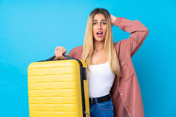 乌拉圭年轻女子度假时带着旅行箱 背景是蓝色的 她感到很惊讶 — 图库照片