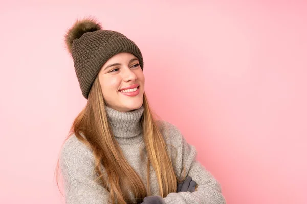 年轻的少女头戴冬帽 从孤立的粉色背景向侧面望去 — 图库照片