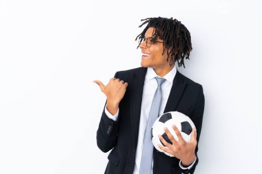 İzole edilmiş beyaz arka plan üzerinde futbol koçu bir ürünü sunmak için kenarı işaret ediyor