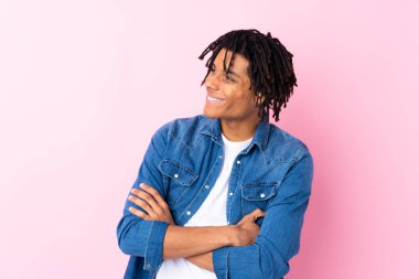 Young African American man with jean shirt over isolated pink background laughing