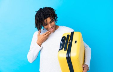 Genç Afrikalı Amerikalı bir gezgin elinde bir bavul tutuyor ve şok olmuş bir yüz ifadesi var.