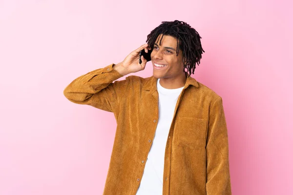 穿着灯芯绒夹克 背景为粉色的年轻非洲裔美国人与手机交谈 — 图库照片