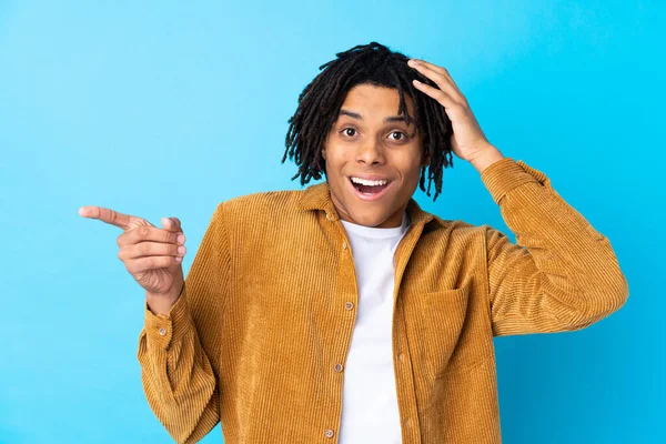 Junger Afroamerikaner Mit Cordjacke Über Blauem Hintergrund Überrascht Und Zeigt — Stockfoto