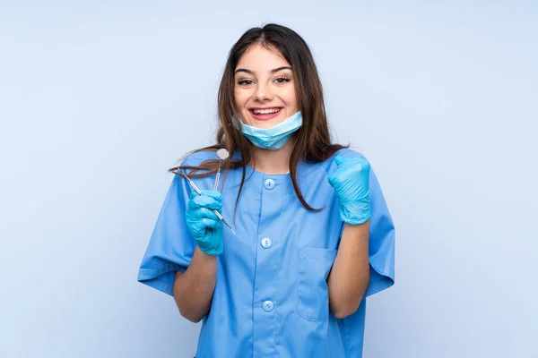 Žena Zubař Drží Nástroje Přes Izolované Modré Pozadí Slaví Vítězství — Stock fotografie