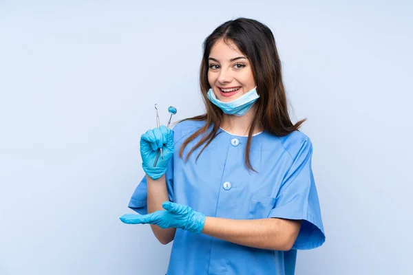 Mulher Dentista Segurando Ferramentas Sobre Fundo Azul Isolado Estendendo Mãos — Fotografia de Stock