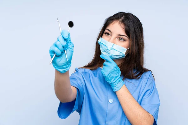 Γυναίκα Οδοντίατρος Κρατώντας Εργαλεία Πάνω Από Απομονωμένο Μπλε Φόντο — Φωτογραφία Αρχείου
