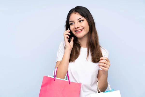 Jovem Morena Sobre Fundo Azul Isolado Segurando Sacos Compras Chamando — Fotografia de Stock