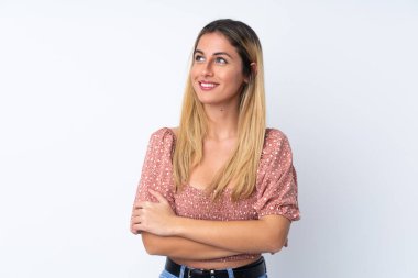 Genç Uruguaylı kadın izole edilmiş beyaz arka planda gülümserken yukarı bakıyor