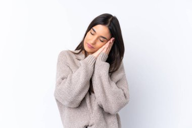 Genç esmer kadın izole edilmiş beyaz arka planda uyku jesti yapıyor.