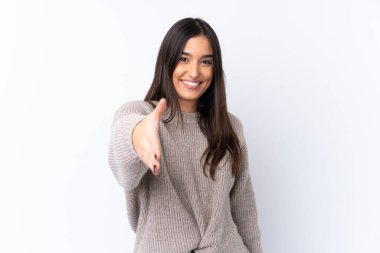 İzole edilmiş beyaz arka planda genç esmer kadın iyi bir anlaşma için el sıkışıyor.