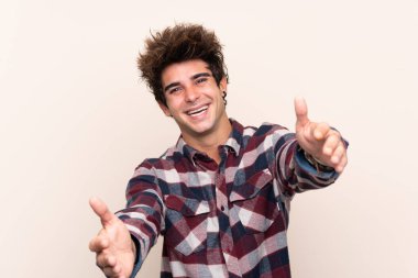 Genç beyaz adam sunuyor ve davet ediyor.