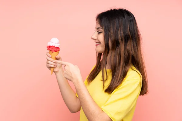 Joven Morena Sosteniendo Helado Corneta Sobre Fondo Rosa Aislado Apuntando —  Fotos de Stock