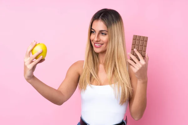 Fiatal Uruguayi Izolált Rózsaszín Háttér Vesz Egy Csokoládé Tabletta Egyik — Stock Fotó