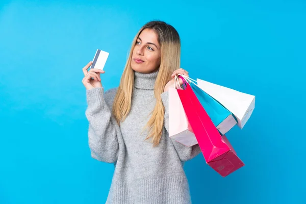 Junge Uruguayische Frau Vor Isoliertem Blauen Hintergrund Mit Einkaufstaschen Und — Stockfoto