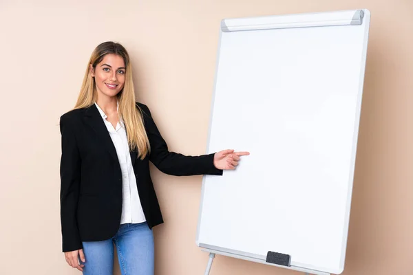 Young Uruguayan woman giving a presentation on white board and pointing it