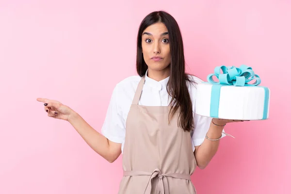 Jeune Femme Avec Gros Gâteau Sur Fond Isolé Surpris Pointant — Photo