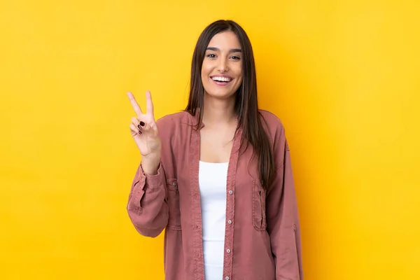 Joven Morena Sobre Aislado Fondo Amarillo Sonriendo Mostrando Signo Victoria —  Fotos de Stock