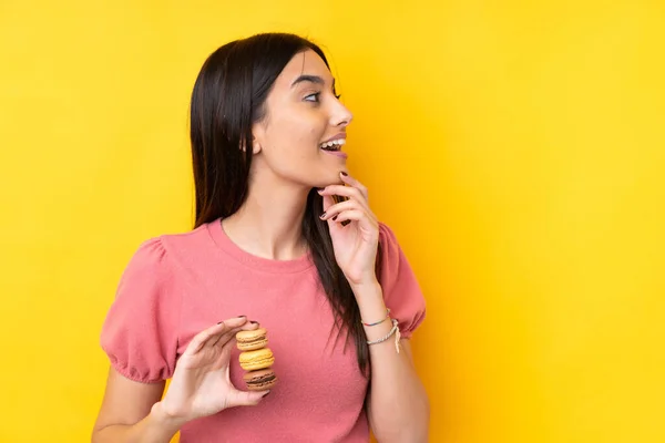 Giovane Donna Bruna Sfondo Giallo Isolato Con Macaron Francesi Colorati — Foto Stock