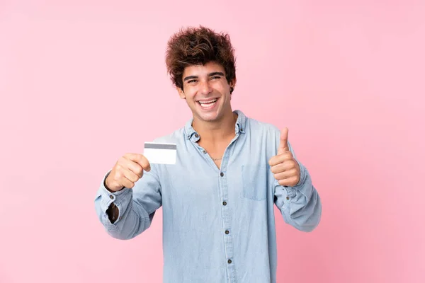 Jovem Caucasiano Sobre Fundo Rosa Isolado Segurando Cartão Crédito — Fotografia de Stock