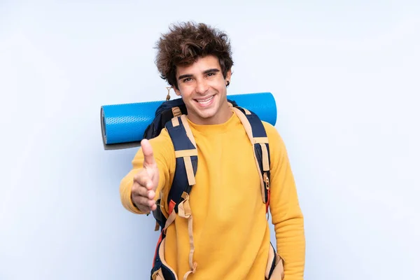 Joven Hombre Montañero Con Una Gran Mochila Sobre Fondo Azul — Foto de Stock