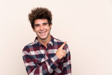 Genç beyaz bir adam bir ürün sunmak için yan tarafı işaret ediyor.