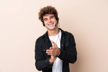 Tele pazarlamacı, arka planda izole edilmiş bir kulaklıkla çalışıyor.