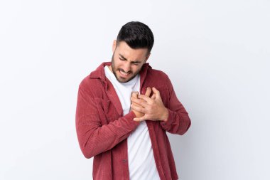 Genç, sakallı, kadife ceket giyen, soyutlanmış beyaz bir arka planı olan, kalbinde ağrı olan yakışıklı bir adam.