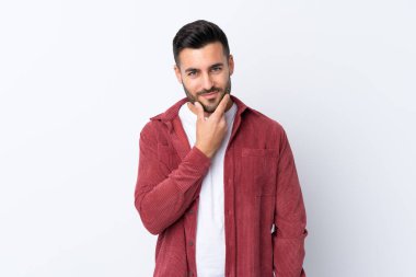 Sakallı, kadife ceket giyen, soyutlanmış beyaz arka planı olan yakışıklı bir genç.