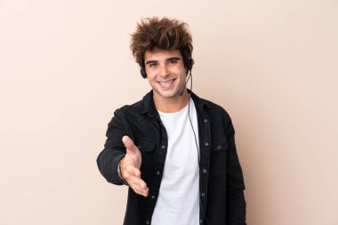 Tele pazarlamacı iyi bir anlaşmadan sonra izole edilmiş arka plan el sıkışması üzerine bir kulaklıkla çalışıyor.