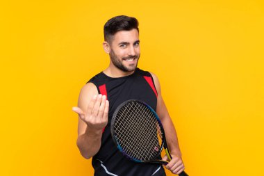 Tenisçi adam, izole edilmiş sarı duvarın üzerinde elini uzatmaya davet ediyor. Gelmene sevindim.