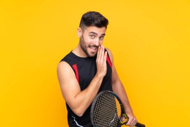 Tenisçi adam sarı duvarın üzerinde bir şeyler fısıldıyor.