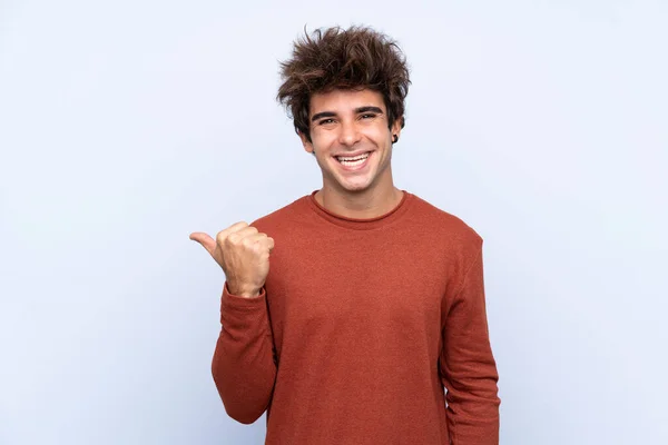 Joven Hombre Caucásico Sobre Fondo Azul Aislado Apuntando Hacia Lado —  Fotos de Stock