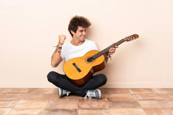 Joven Hombre Caucásico Con Una Guitarra Sentada Suelo Celebrando Una —  Fotos de Stock