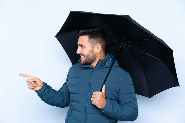 製品を提示するために側面を指して隔離された背景に傘を持っている男 — ストック写真