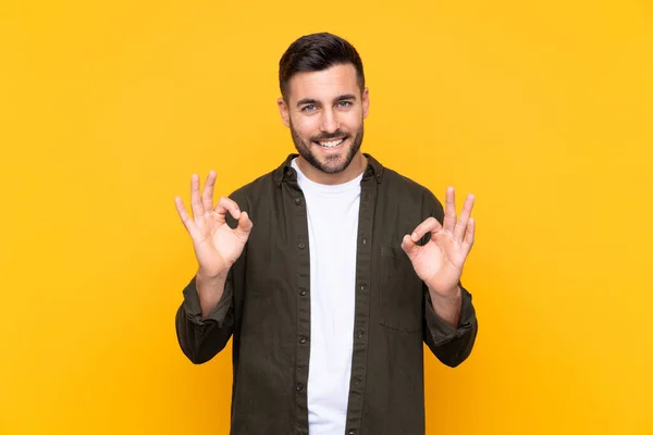 Muž Nad Izolovaným Žlutým Pozadím Ukazující Znamení Prsty — Stock fotografie