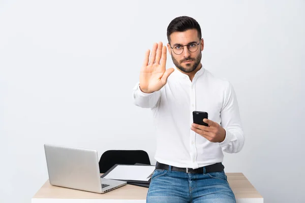 Joven Hombre Negocios Sosteniendo Teléfono Móvil Haciendo Gesto Parada Con — Foto de Stock