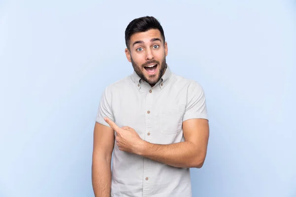 Jonge Knappe Man Met Baard Geïsoleerde Blauwe Achtergrond Wijzende Vinger — Stockfoto