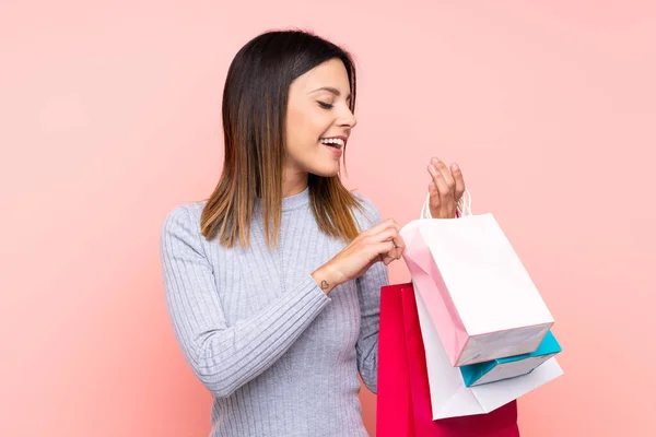 Kvinna Över Isolerad Rosa Bakgrund Håller Shoppingväskor — Stockfoto