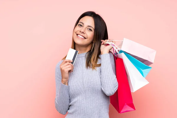 Vrouw Geïsoleerde Roze Achtergrond Met Boodschappentassen Een Creditcard — Stockfoto