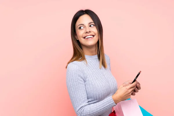 Woman Isolated Pink Background Holding Shopping Bags Mobile Phone — Stock Photo, Image