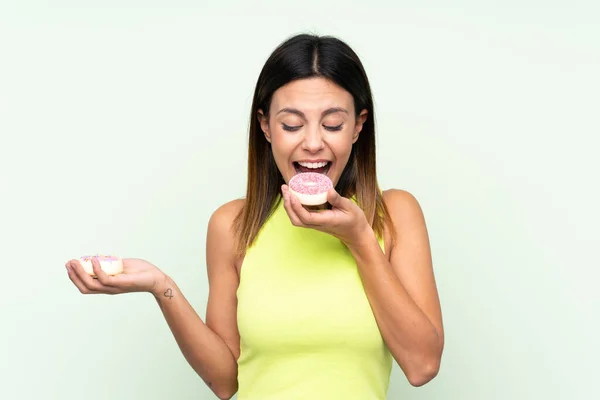 Tecrit Edilmiş Yeşil Arka Planda Donut Yiyen Bir Kadın — Stok fotoğraf