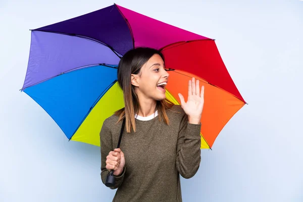 Joven Morena Sosteniendo Paraguas Sobre Una Aislada Pared Azul Gritando — Foto de Stock